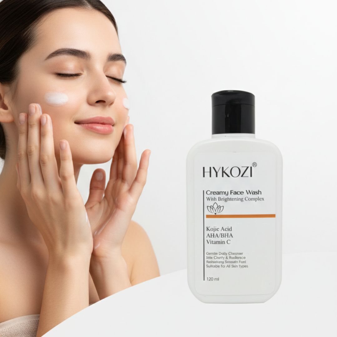 Woman applying cream to her face with a bottle of HYKOOZI Creamy Face Wash next to her.
